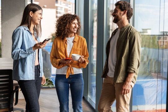 Smiling businesspeople talking during coffee break in office