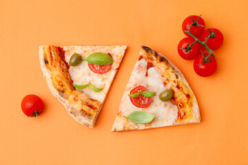 Slices of delicious pizza and tomatoes on orange background, flat lay