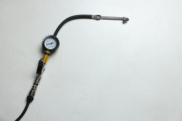 One tire inflation gun with gauge on light background, top view. Space for text