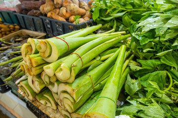 Fresh bundles of green stems neatly arranged on market stall for sale at local market in Phuket, Thailand. Thai market, culinary culture, organic farming