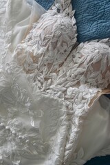 White wedding dress with lace and beading closeup against blue background