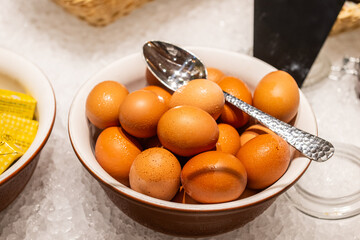 The brown eggs in the bowl offer an eye-catching visual appeal as part of a fresh and hygienic...