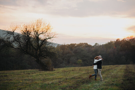 Senior couple embracing in autumn sunset light.