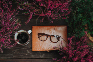 Reading glasses resting on notebook in autumn garden