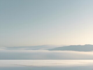 Fototapeta premium Serene coastal landscape with soft morning mist rolling over calm ocean waters and distant mountains