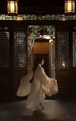 Dancer in flowing garment amidst traditional architecture.