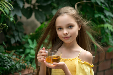 Cute little girl is drinking tea