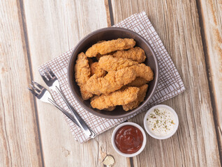 Breaded chicken bites in a plate over wooden table