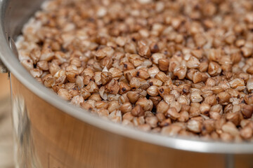 Plate with tasty buckwheat porridg.Boiled buckwheat porridge in ceramic pot on wooden background.