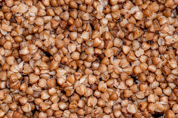Plate with tasty buckwheat porridg.Boiled buckwheat porridge in ceramic pot on wooden background.