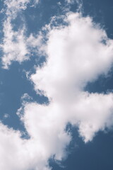 Obraz premium White fluffy clouds floating in a deep blue sky on a sunny day. Minimalist and peaceful scene capturing the beauty of nature.