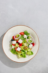 Greek salad in ceramic bowl, bright lighting, overhead composition, minimalist empty space
