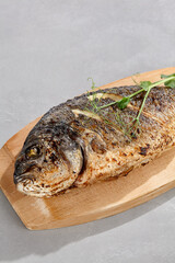 Grilled dorado whole fish, bright lighting, minimal composition, ample copyspace