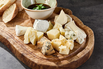 Cheese platter with brie, parmesan, camembert, gorgonzola, rustic lighting, overhead composition