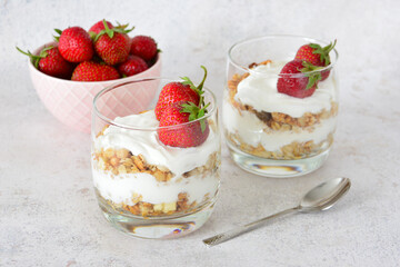 Strawberry Yogurt Parfaits with Granola in Glass Cups with a bowl of fresh strawberries