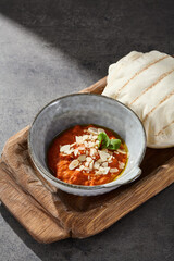 Muhammara roasted pepper spread in rustic bright overhead composition with pita bread on wooden board