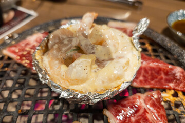 焼肉の網で焼かれるエビのチーズ焼き