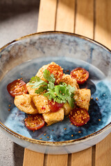 Crispy eggplant with sweet chili sauce and cherry tomatoes, bright natural lighting, overhead composition