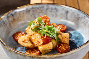 Crispy eggplant in sweet chili sauce with cherry tomatoes, rustic lighting, overhead composition