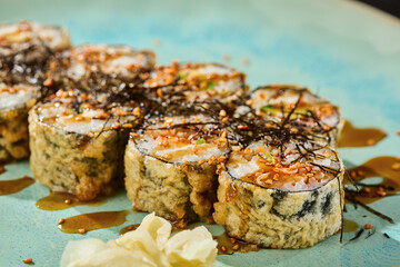 Tempura salmon roll, moody lighting, overhead composition with spicy sauce on blue ceramic plate