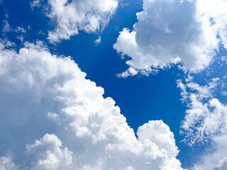 Fluffy white clouds in a bright blue sky during a sunny day