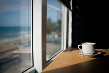 hot cup of coffee on the table in the morning, relaxing time, by the window