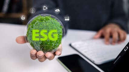 Hand holding a green globe with ESG text, surrounded by icons for wind energy, tree planting, CO2 reduction, and business growth, symbolizing sustainability and corporate social responsibility.