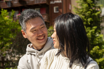 Fototapeta premium Asian couple sharing a tender moment outdoors in the mountains