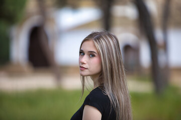 portrait of young and beautiful blonde woman, wearing jeans, black shirt walking in the countryside...