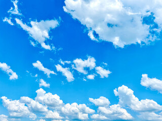 Fluffy white clouds scattered in a bright blue sky on a sunny day