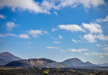 “ volcanic landscape with rugged lava fields and clear blue sky at Lanzarote, Canary Islands”