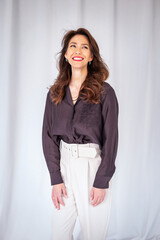 tudio shot of a brunette haired woman standing against isolated background wiht copy space