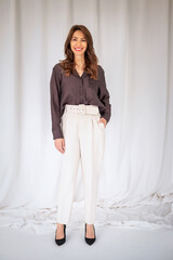 tudio shot of a brunette haired woman standing against isolated background wiht copy space