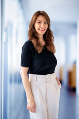 Confident mid aged woman standing in the office