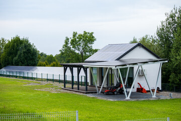 Modern white house with solar panels on the roof, green lawn