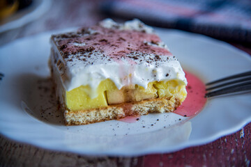 Banana cake with chocolate on top on a wooden table..