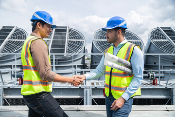Engineers shaking hands after rooftop project meeting