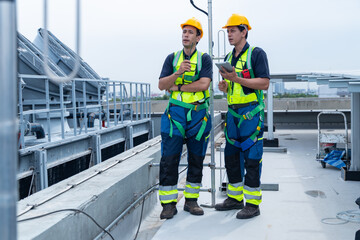 Construction workers coordinating rooftop solar installation
