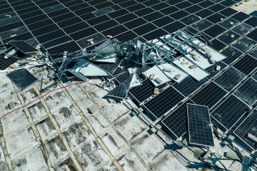 Aerial view of damaged by hurricane wind photovoltaic solar panels mounted on industrial building...