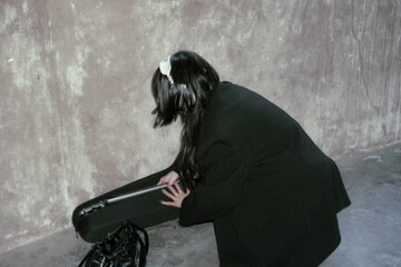 Woman in black coat interacting with a case.