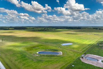 Water reservoirs for cows grazing on green farm pasture. Drinking ponds at free range farm. Feeding...