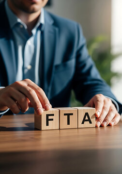 Businessman arranging fta wooden blocks on a table representing free trade agreement