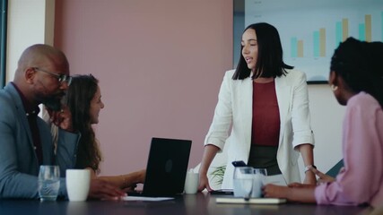 Young businesswoman giving presentation to diverse team in boardroom of office during daytime - Powered by Adobe