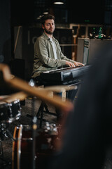 A talented pianist performs passionately on a digital piano at a music studio. The atmosphere highlights creativity, musical artistry, and teamwork among band members.