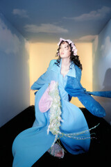 Fashion model in blue outfit with whimsical accessories.