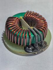 An up-close shot displays the details of an inductor coil on a circuit board, emphasizing its...