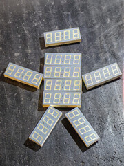 Seven-segment displays form a unique arrangement on a textured surface, showcasing electronic...