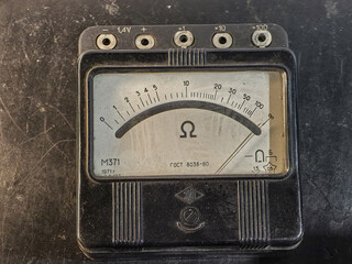 A close-up shot of a vintage analog multimeter displaying an Ohms reading.