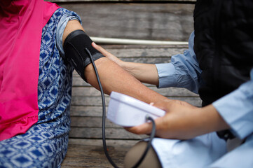 Female Healthcare Worker Checking Blood Pressure of Elderly Woman in Rural Area During Medical Visit