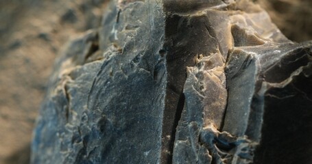 Close-up of broken slate rock with sharp vertical splits and textured layers
